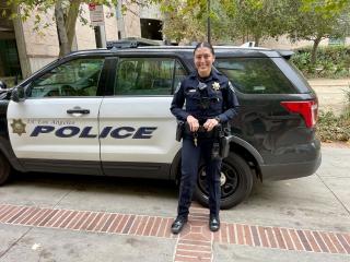 Officer Melody Mendoza standing in front of a UCPD vehicle