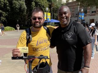 Officer London McBride rewards a student with a meal voucher for walking his scooter