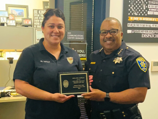 Sonia Del Castillo and Chief John Thomas holding Dispatcher of the Year award